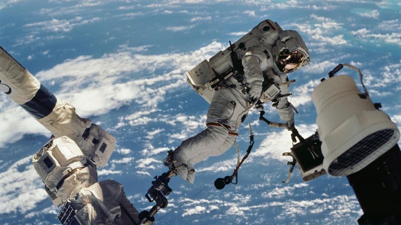 astronaut David A. Wolf, STS-112 mission specialist, participates in the mission's first session of extravehicular activity. He's photographed floating above the Earth.
