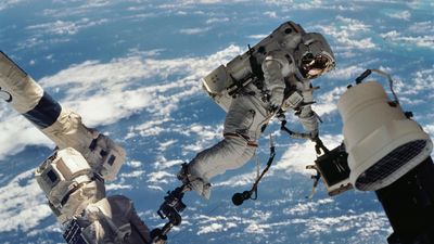 astronaut David A. Wolf, STS-112 mission specialist, participates in the mission's first session of extravehicular activity. He's photographed floating above the Earth.