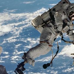 astronaut David A. Wolf, STS-112 mission specialist, participates in the mission's first session of extravehicular activity. He's photographed floating above the Earth.