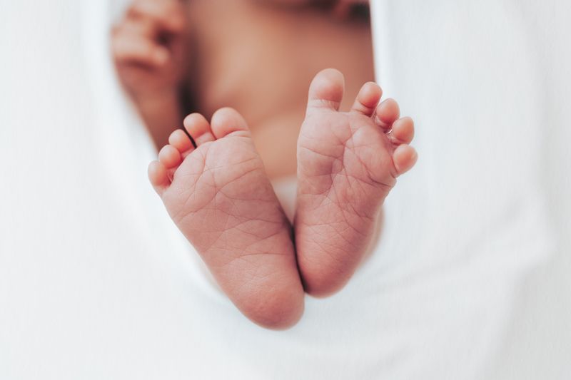 Newborn baby feet photographed on white background