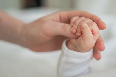 hand of a newborn baby gripping onto an adult's thumb