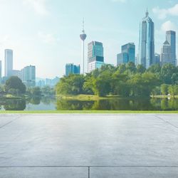 Empty cement floor with lake garden and modern city skyline in backgroun