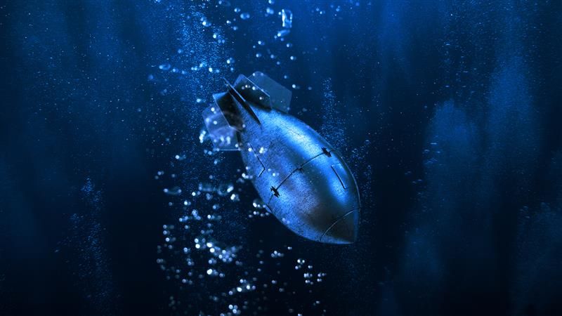 A digital photo showing an old fashioned nuclear bomb falling through a dark watery background suggesting it is heading towards the ocean floor. The bomb has the classic fish shape and is slightly obscured by bubbles.  