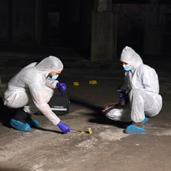 Crime scene, people and forensics at night with swab, evidence or DNA sample clue in abandoned warehouse. CSI team, hazmat suit or investigation in building for legal service, inspection or pathology