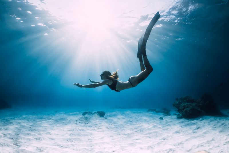 woman free diving underwater