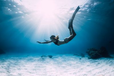 woman free diving underwater