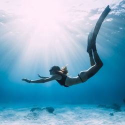 woman free diving underwater