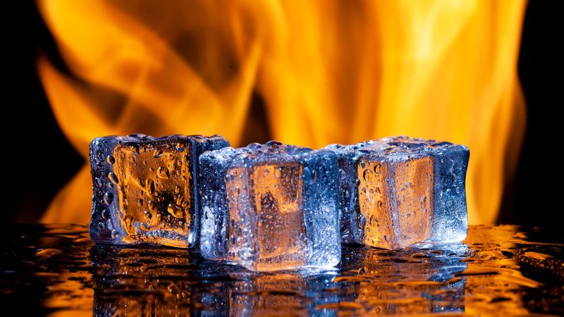 three icecubes melting with a flames behind them