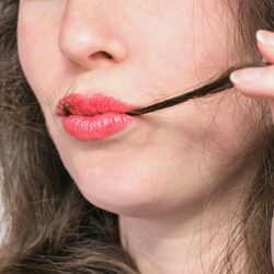 Woman with strands of hair in her mouth