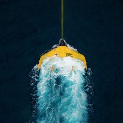 the bright yellow tidal kite luna 12 with the words Faroe Islands Space Program, on the surface of the dark blue atlantic.