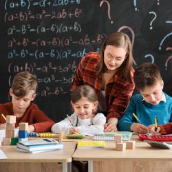 Children with math teacher during lesson in classroom