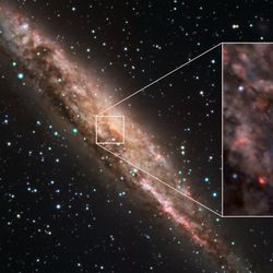 The galaxy is a spiral almost edge on, an inset shows the dust rich center with two tendrils stretching out of the very core. 