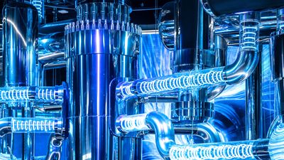 A series of tubes with light spiralling inside connect to a large chrome cylinder.