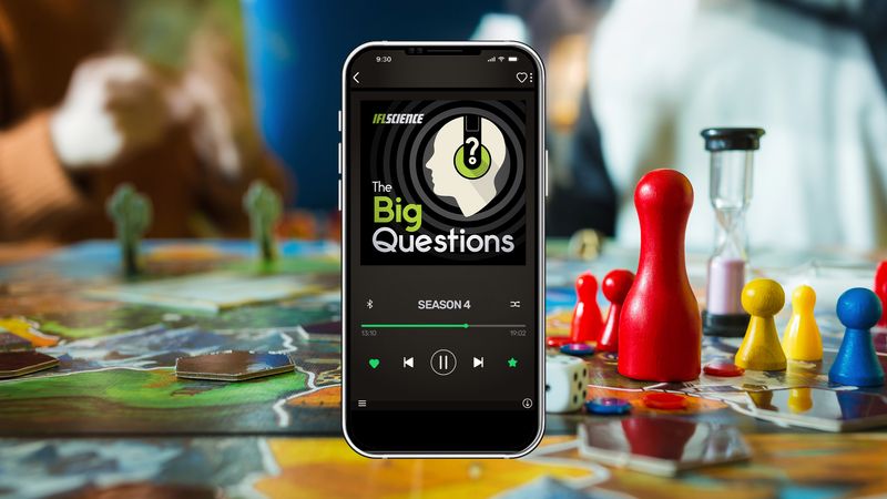 a smartphone playing an episode of The Big Questions, with people playing games in the background