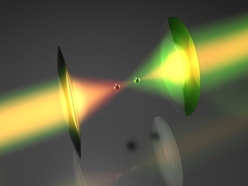 Artist impression of the setup. two different colored laser beams pass through some lenses and keep two little spheres hover mid-air