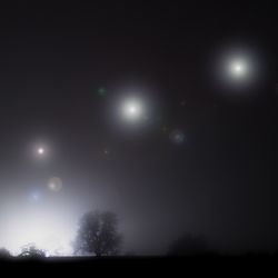 Three glowing orbs in the night sky