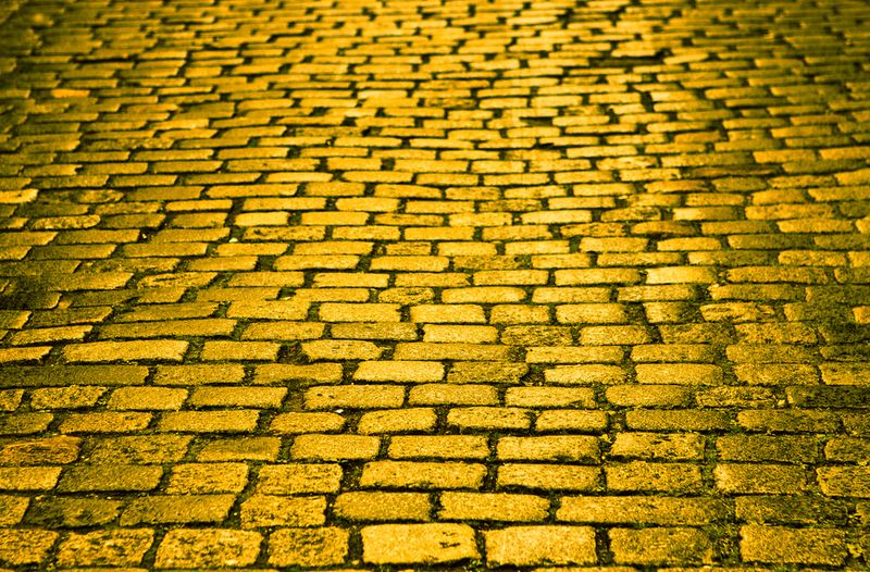 A yellow brick road in a street.