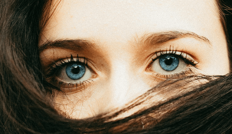 A women with blue eyes and hair covering her face