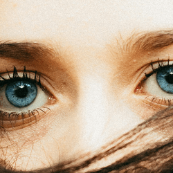 A women with blue eyes and hair covering her face