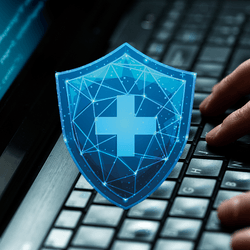 close up of hands on a laptop keyboard with some code on the screen, overlaid with a shield containing a cross to indicate health data