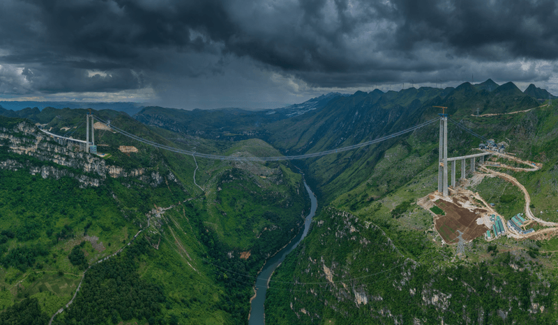 The Huajiang Grand Canyon Bridge (pictured here under construction) is part of an expressway in Zhenfeng County in the southwest of Guizhou province, China. 