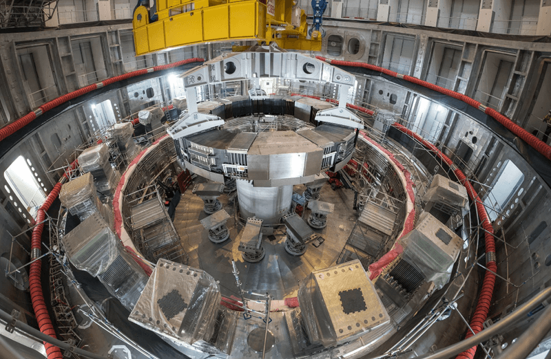 Installation of the first superconducting magnet, Poloidal Field Coil #6, in the tokamak pit at the ITER construction site. The gigantic Central Solenoid will soon be mounted in the center.