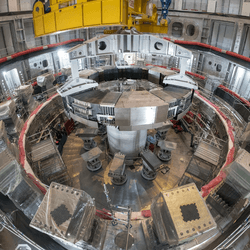 Installation of the first superconducting magnet, Poloidal Field Coil #6, in the tokamak pit at the ITER construction site. The gigantic Central Solenoid will soon be mounted in the center.