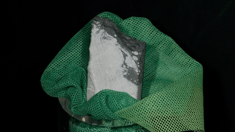 a slab of a white/gray mineral wrapped in a green gauze