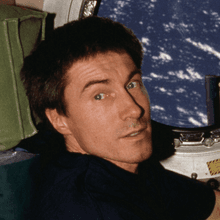 Russian cosmonaut Sergei Krikalev positioned at a port hole on the Zvezda service module of the International Space Station during Expedition 1 as Space Shuttle Atlantis approaches for a link-up