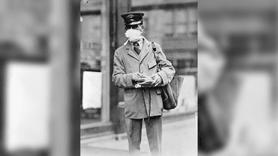 black and white photo of a man in a uniform, possibly a postman, wearing a white mask during the flu pandemic of 1918-1920