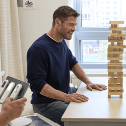 chris hemsworth playing jenga with pads stuck to his stomach that deliver electric shocks